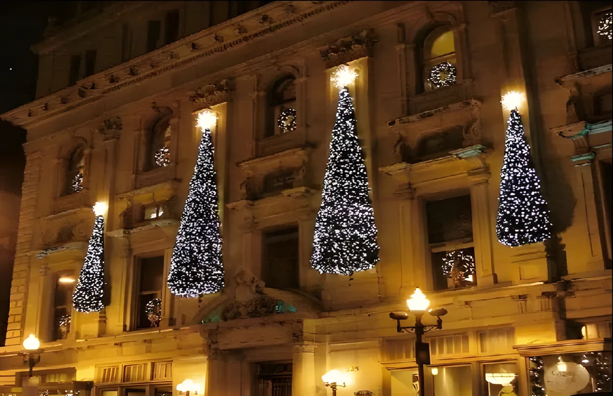 Árboles de luz frente a una fachada histórica