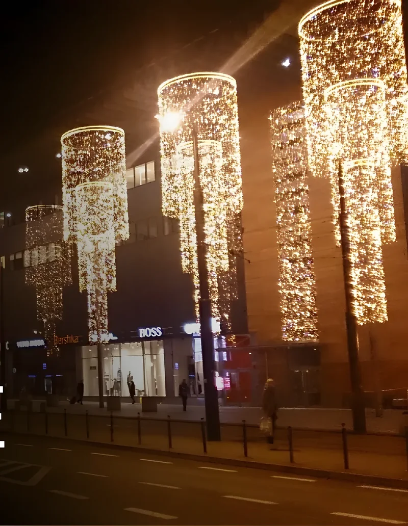 Avenida iluminada con figuras en postes