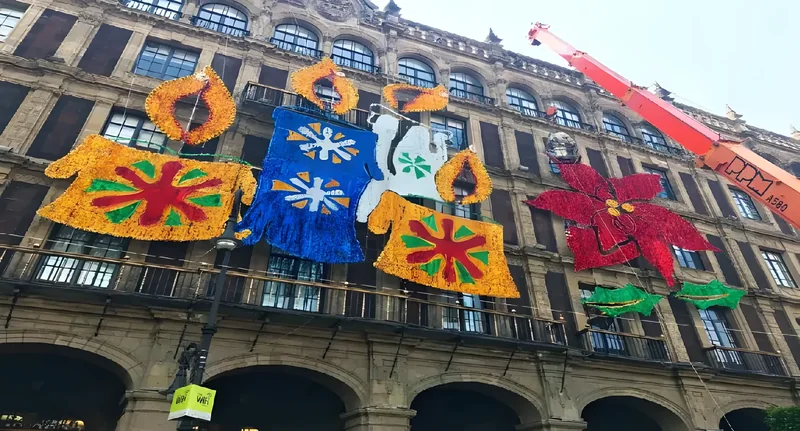 Montaje de figuras luminosas sobre la fachada de un edificio histórico con grúa